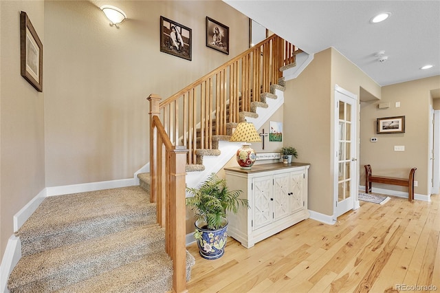 staircase with french doors and hardwood / wood-style floors