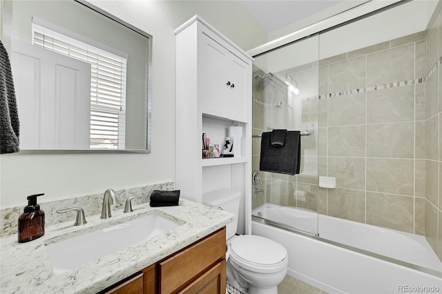 full bathroom with bath / shower combo with glass door, vanity, and toilet