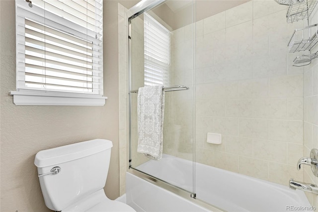 bathroom with shower / bath combination with glass door and toilet