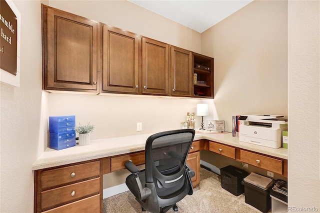 carpeted home office featuring built in desk