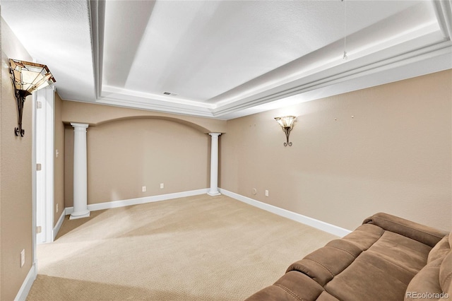 unfurnished living room with decorative columns, a raised ceiling, and carpet flooring