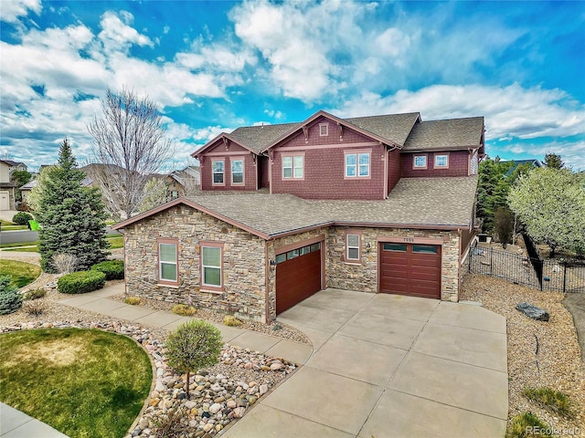 craftsman house with concrete driveway, roof with shingles, fence, and an attached garage