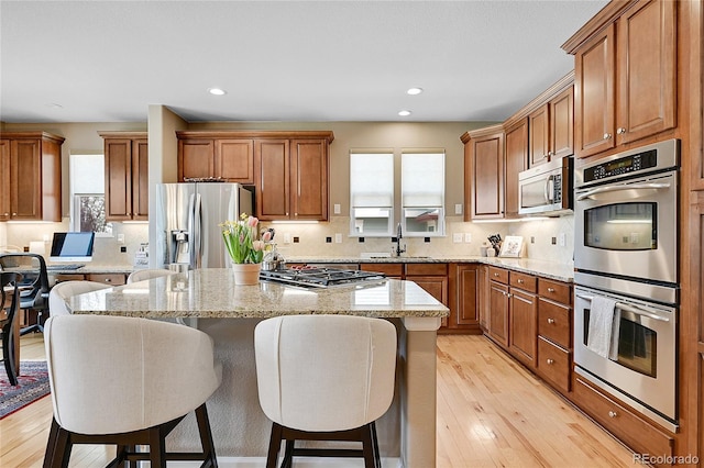 7999 S Blackstone Pkwy, Aurora, CO 80016 - kitchen featuring appliances with stainless steel finishes, plenty of natural light, a center island, brown cabinets, and recessed lighting