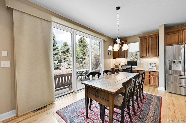 7999 S Blackstone Pkwy, Aurora, CO 80016 - dining room with light wood-style flooring and a chandelier