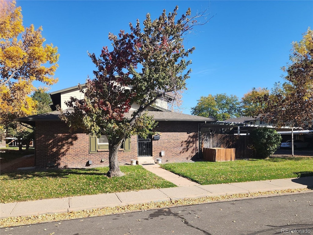 obstructed view of property with a front lawn