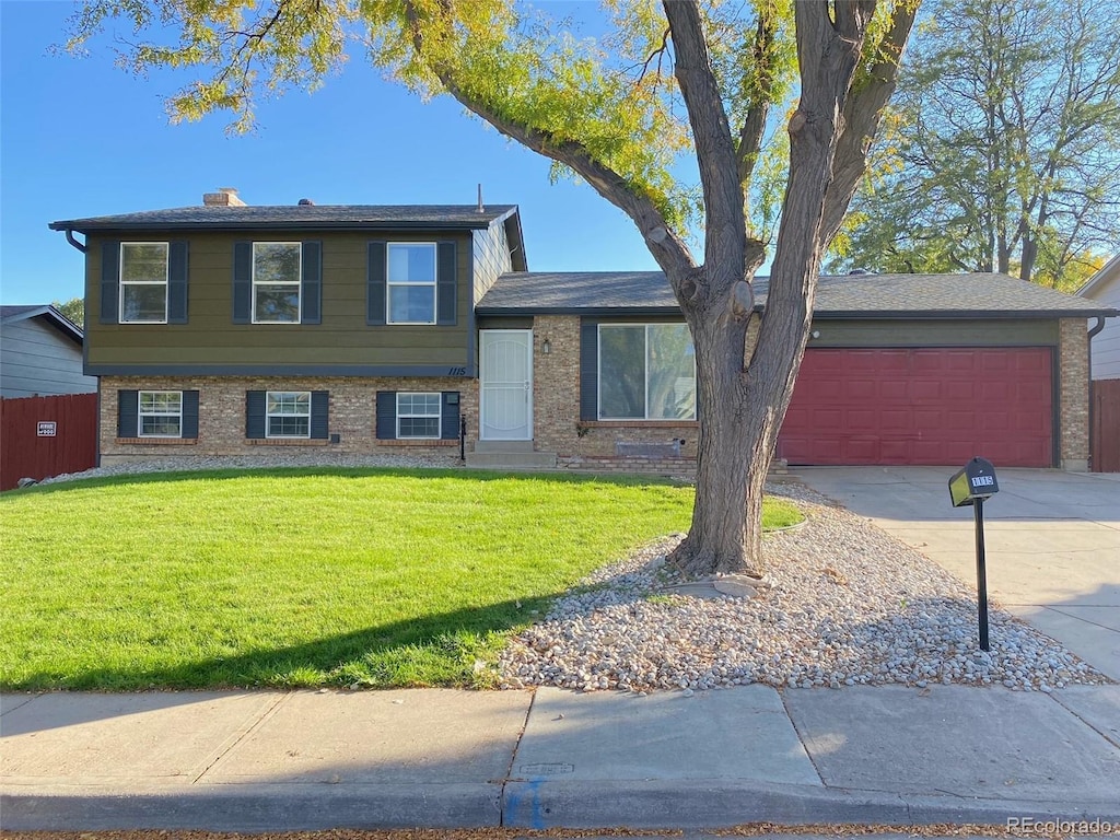 split level home featuring a front lawn and a garage