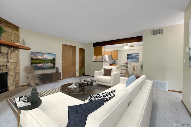 3335 S Ammons St Unit 6-105, Lakewood, CO 80227 - living area featuring light carpet, ceiling fan, and a stone fireplace