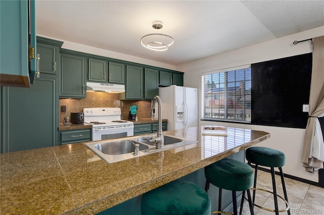 kitchen featuring white appliances, green cabinets, and a breakfast bar area