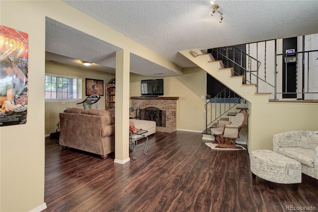 living room featuring a brick fireplace, a textured ceiling, and dark hardwood / wood-style flooring