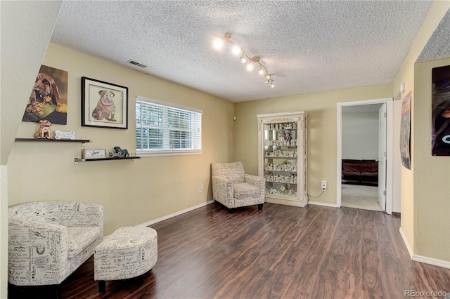 living area featuring hardwood / wood-style flooring and a textured ceiling