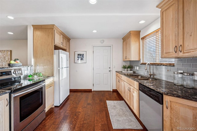 kitchen featuring dark wood-type flooring, light brown cabinetry, sink, dark stone countertops, and stainless steel appliances