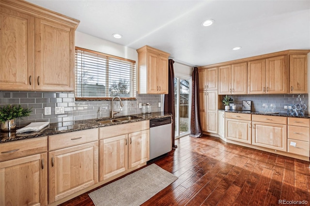 kitchen with sink, dark hardwood / wood-style floors, dishwasher, dark stone counters, and backsplash