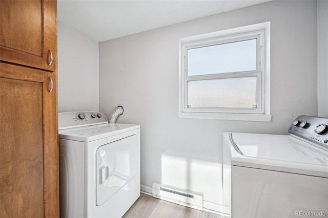 laundry area featuring cabinets, washing machine and dryer, and baseboard heating