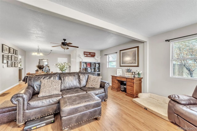 313 E Grant Ave, Fowler, CO 81039 - living room featuring light wood-type flooring, a textured ceiling, ceiling fan, and a chandelier