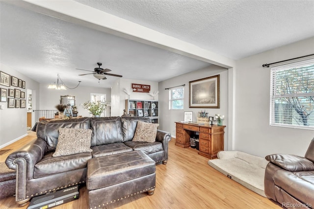 313 E Grant Ave, Fowler, CO 81039 - living area with light wood-style flooring, a textured ceiling, a chandelier, and a ceiling fan