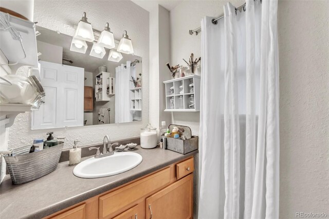 313 E Grant Ave, Fowler, CO 81039 - bathroom with a textured wall, vanity, and curtained shower