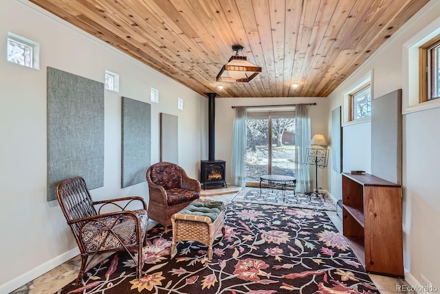 sitting room featuring wood ceiling, baseboards, and a wood stove