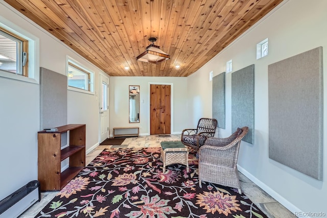 living area with crown molding, wood ceiling, and baseboards