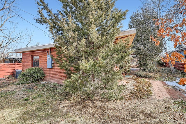 exterior space featuring brick siding and fence