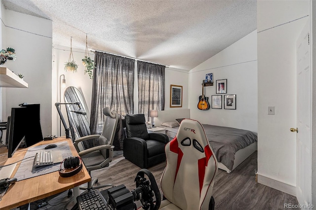 bedroom featuring vaulted ceiling, hardwood / wood-style floors, and a textured ceiling