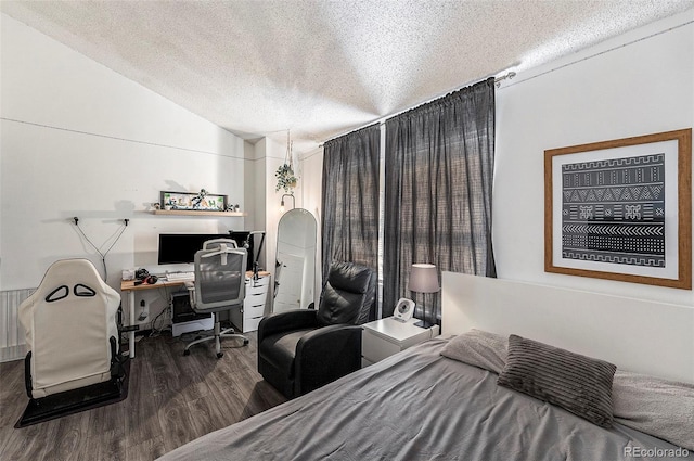 bedroom featuring vaulted ceiling, hardwood / wood-style floors, and a textured ceiling