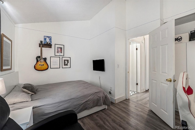 bedroom featuring vaulted ceiling and dark wood-type flooring