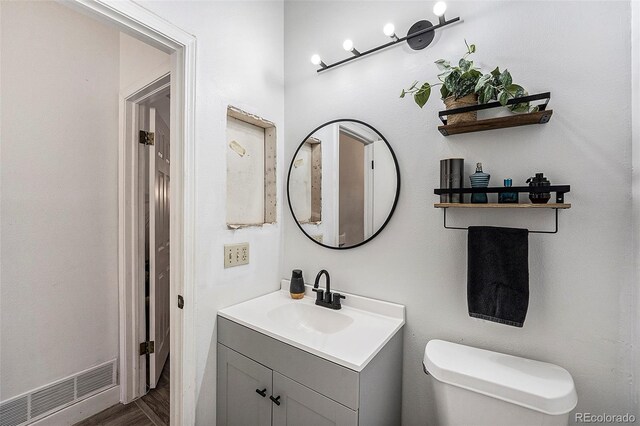 bathroom with vanity, hardwood / wood-style floors, and toilet