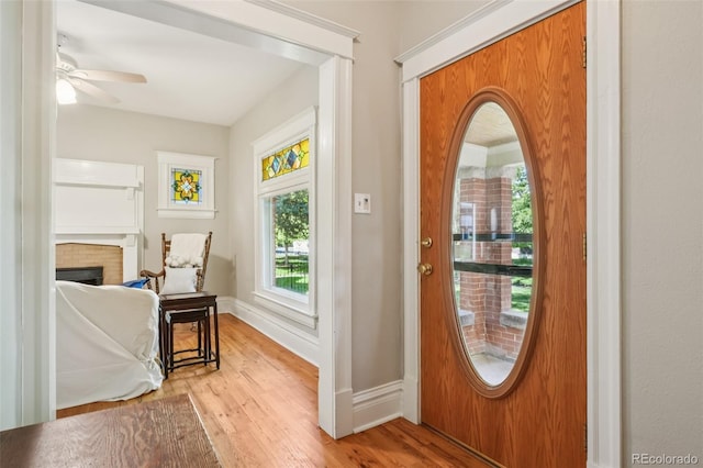 2360 S Milwaukee St, Denver, CO 80210 - foyer entrance with light wood-style floors, a ceiling fan, and a brick fireplace