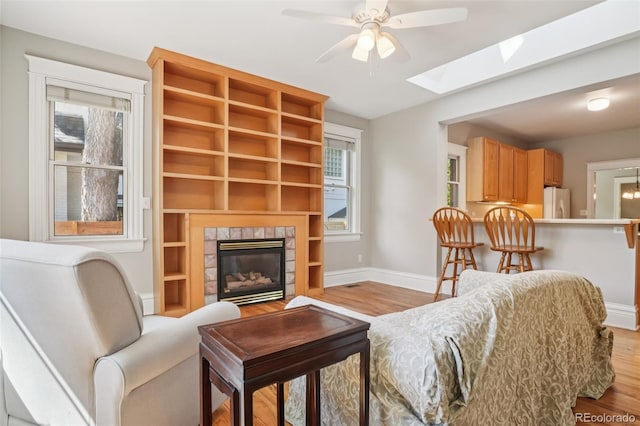 2360 S Milwaukee St, Denver, CO 80210 - living room featuring ceiling fan, wood finished floors, a skylight, and a fireplace
