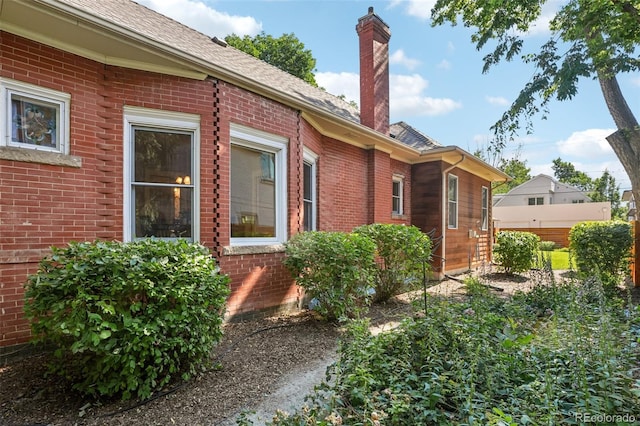 2360 S Milwaukee St, Denver, CO 80210 - view of home's exterior featuring brick siding, a chimney, and a shingled roof