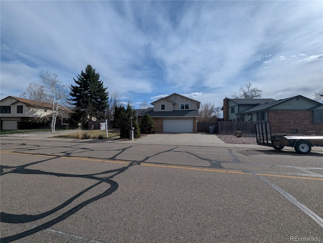 2325 15th Ave, Longmont, CO 80503 - view of front of property with concrete driveway, fence, an attached garage, and brick siding