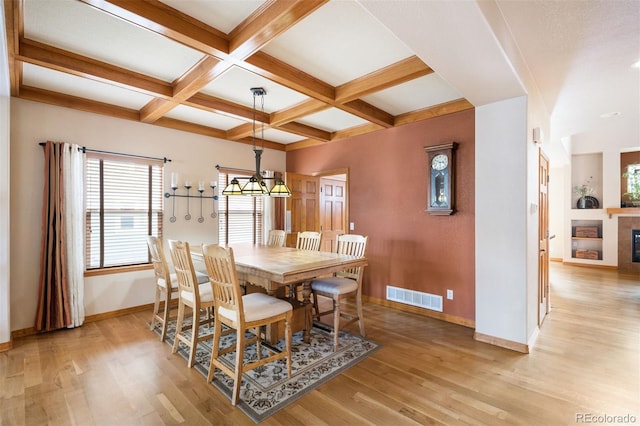 dining room featuring beamed ceiling, light hardwood / wood-style floors, and coffered ceiling