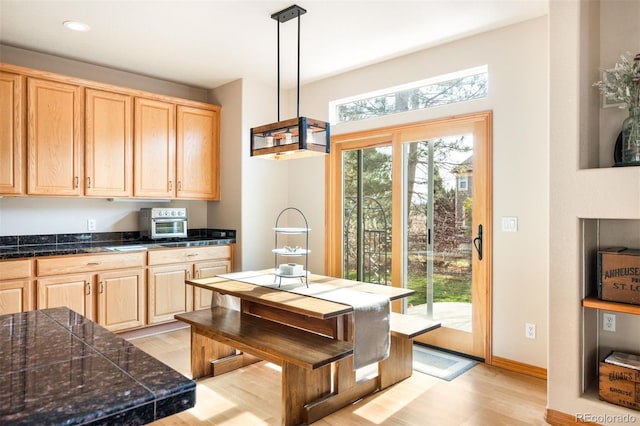 kitchen featuring hanging light fixtures, light brown cabinetry, and light hardwood / wood-style flooring