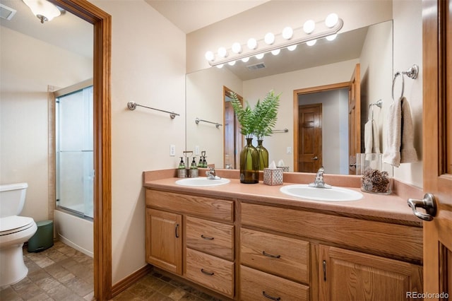 full bathroom featuring vanity, enclosed tub / shower combo, and toilet