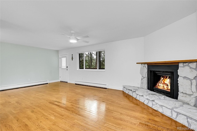 26752 Vosler St, Conifer, CO 80433 - unfurnished living room with a baseboard heating unit, a fireplace, wood finished floors, and baseboards