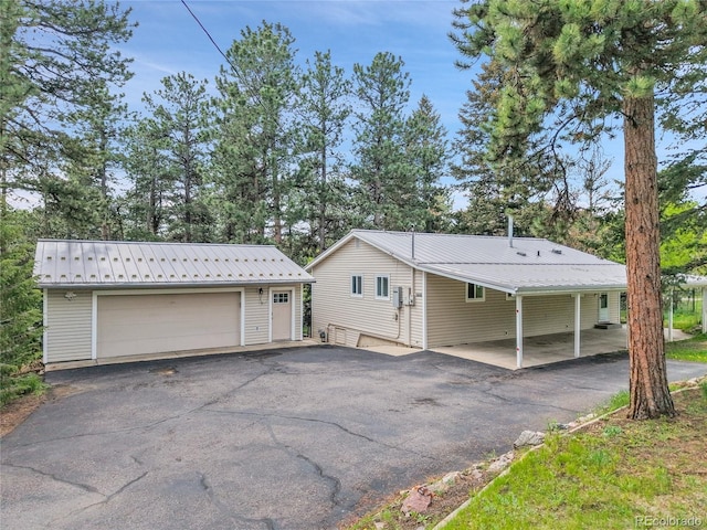 26752 Vosler St, Conifer, CO 80433 - view of front of house featuring a garage, an outbuilding, and metal roof