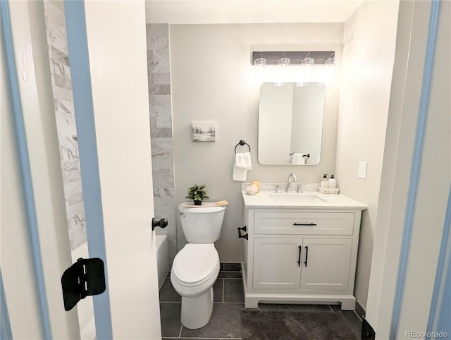 bathroom featuring vanity, toilet, baseboards, and tile patterned flooring