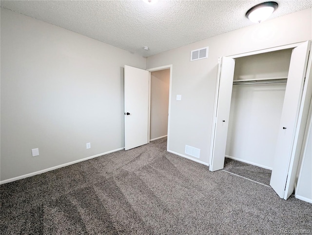 unfurnished bedroom with carpet flooring, visible vents, a closet, and a textured ceiling