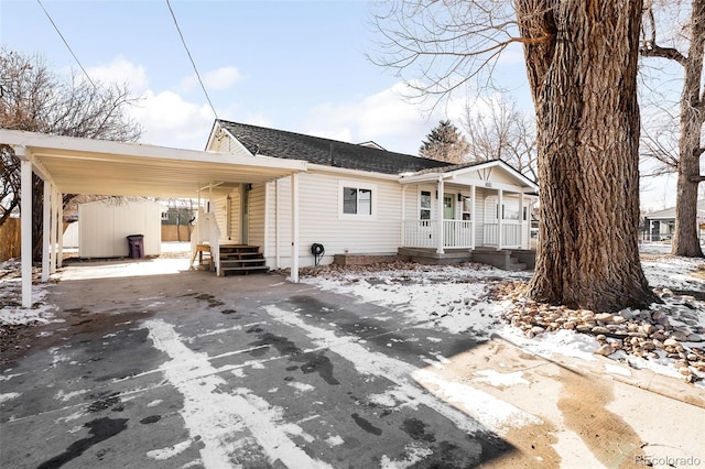 snow covered back of property featuring a porch