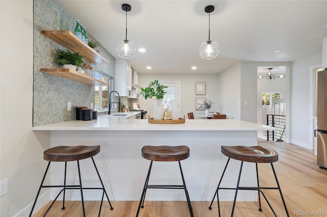 kitchen featuring decorative backsplash, pendant lighting, and kitchen peninsula