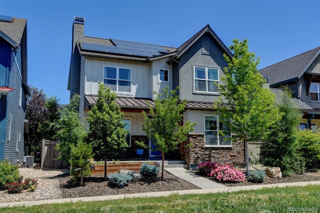 1362 Golden Eagle Way, Louisville, CO 80027 - view of front of property with a standing seam roof, solar panels, a chimney, board and batten siding, and stone siding