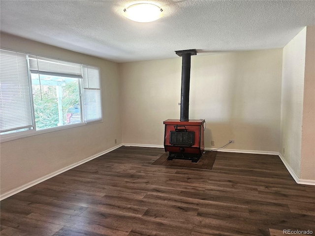 7331 Clay St, Westminster, CO 80030 - unfurnished living room featuring a wood stove, a textured ceiling, and dark wood-style floors