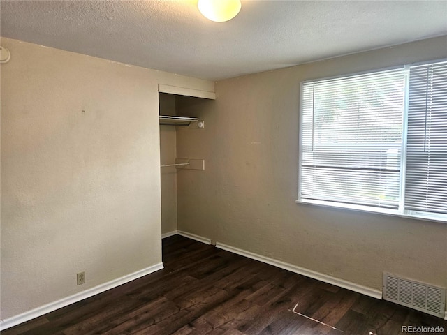 7331 Clay St, Westminster, CO 80030 - unfurnished bedroom with multiple windows, dark wood finished floors, a closet, and a textured ceiling
