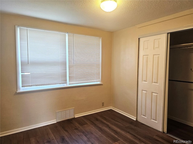 7331 Clay St, Westminster, CO 80030 - unfurnished bedroom featuring dark wood-style flooring, a closet, and a textured ceiling