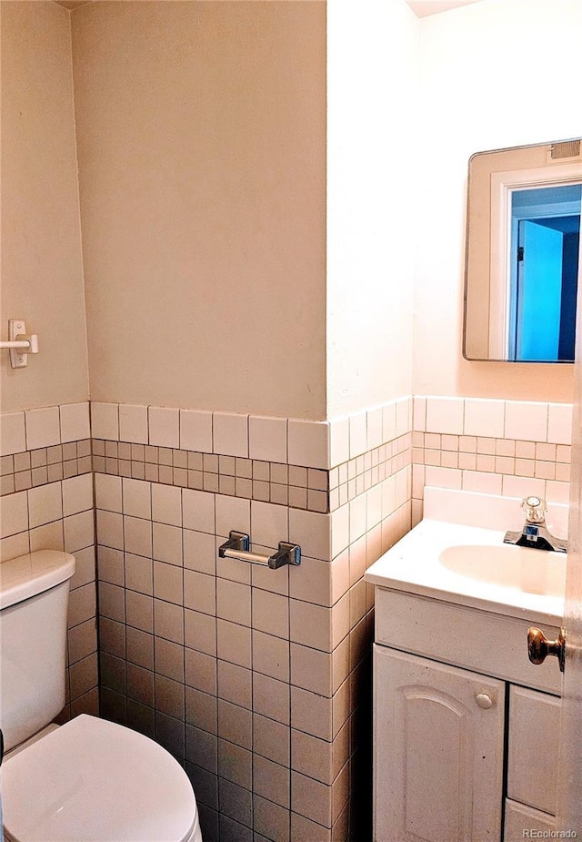 7331 Clay St, Westminster, CO 80030 - bathroom featuring tile walls, vanity, and a wainscoted wall
