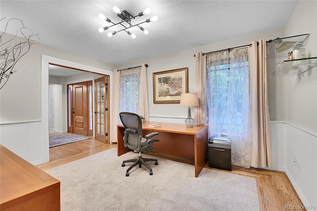 7030 S Fillmore Ct, Centennial, CO 80122 - home office with healthy amount of natural light, a textured ceiling, wood finished floors, a wainscoted wall, and a chandelier