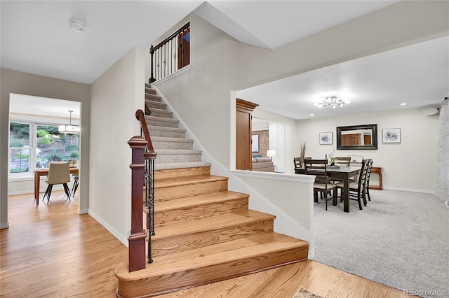 7030 S Fillmore Ct, Centennial, CO 80122 - staircase featuring a chandelier, wood finished floors, and baseboards