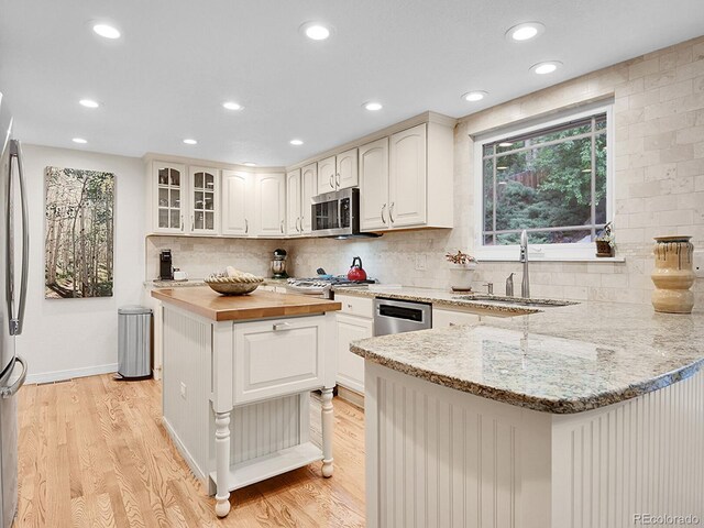 7030 S Fillmore Ct, Centennial, CO 80122 - kitchen with wooden counters, a peninsula, a sink, light wood-style flooring, and recessed lighting