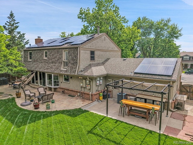 7030 S Fillmore Ct, Centennial, CO 80122 - rear view of property with roof mounted solar panels, a chimney, a patio area, central AC, and a shingled roof