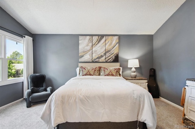 carpeted bedroom featuring a textured ceiling and vaulted ceiling